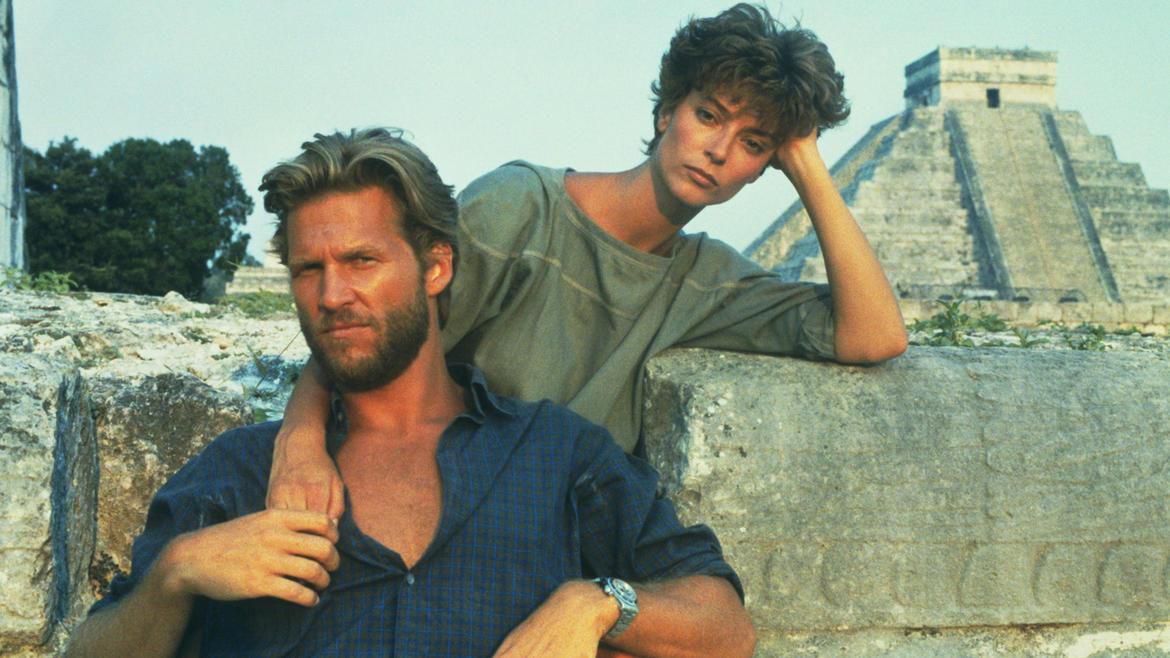 Un homme barbu et une femme aux cheveux courts posant devant une pyramide du Yucatan dans Against All Odds.