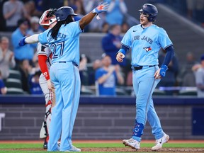 Le receveur des Blue Jays Danny Jansen, à droite, célèbre avec Vladimir Guerrero Jr. après avoir réussi un circuit de deux points en cinquième manche contre les Twins au Rogers Centre de Toronto, le samedi 11 mai 2024.