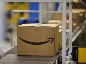 Des boîtes sur un tapis roulant lors d'une visite du centre de distribution Amazon à Aurora, au Colorado, le 3 mai 2018. Postes Canada s'attaque à une échappatoire utilisée par les habitants du Nunavut pour obtenir la livraison gratuite avec Amazon Prime.