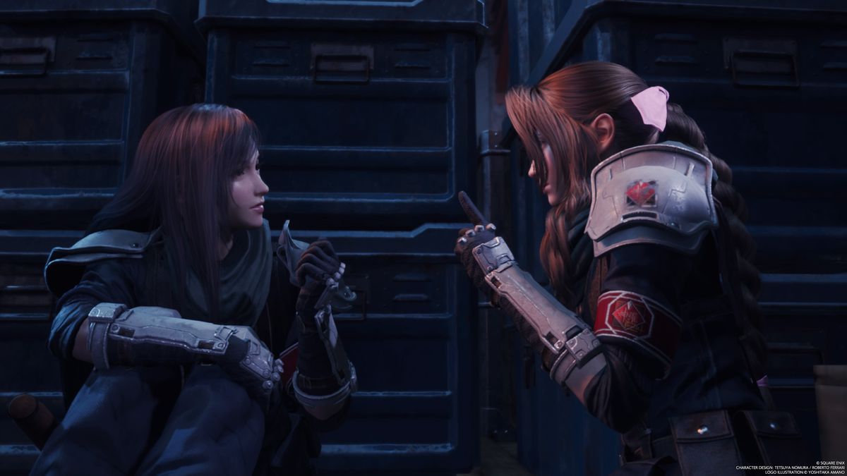 Une image montrant Tifa et Aerith en train d'avoir une conversation privée dans Final Fantasy 7 Rebirth.  Ils sont dans une pièce sombre et se penchent pour se parler. 