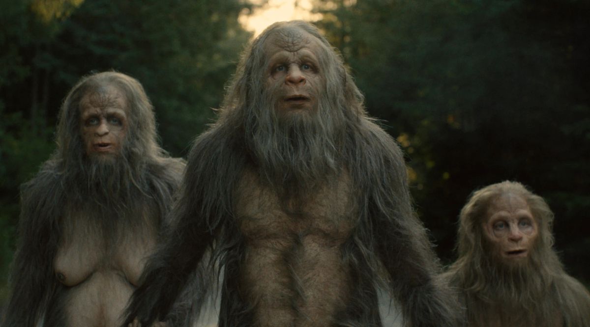 Trois créatures sasquatch regardant avec étonnement quelque chose hors écran.