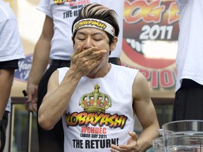 Takeru Kobayashi, champion de la cuisine de compétition, se met des hot-dogs dans la bouche avant de remporter le 3e championnat annuel de dégustation de hot-dogs de la côte ouest du Derby Deli & Dueling Piano Bar en 2011.