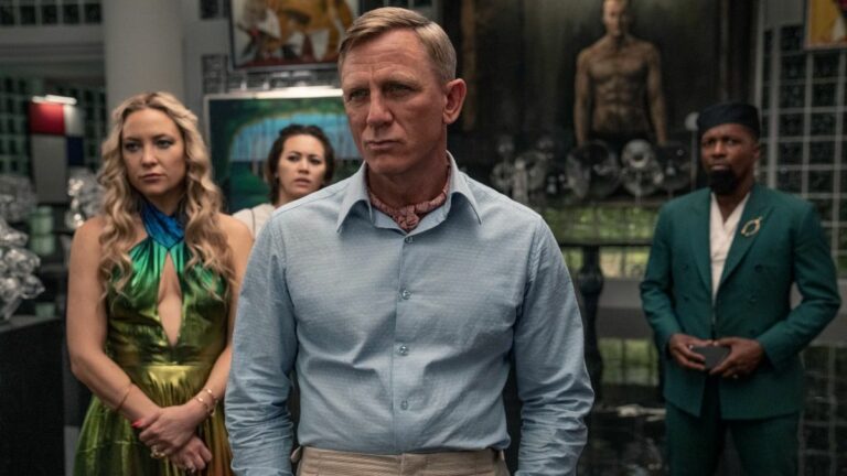 Glass Onion: A Knives Out Mystery (2022). (L - R) Kate Hudson as Birdie, Jessica Henwick as Peg, Daniel Craig as Detective Benoit Blanc, and Leslie Odom Jr. as Lionel. Cr. John Wilson/Netflix © 2022.