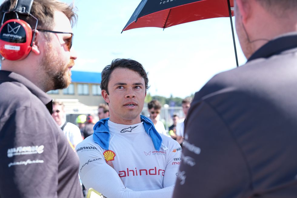 le pilote de formule e nyck de vries s'entretient avec les membres de l'équipe sur la grille avant une course