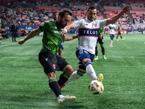 Sergio Camargo du Cavalry FC, à gauche, et Luís Martins, des Whitecaps de Vancouver, à droite, s'affrontent pour la possession du ballon lors de la première moitié d'un match de football quart de finale du Championnat canadien, à Vancouver, le mardi 21 mai 2024.