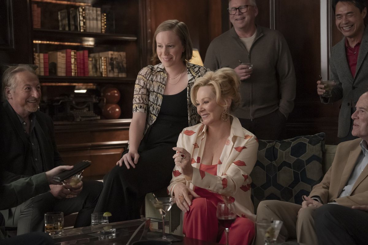 Deborah (Jean Smart) est assise en souriant avec Ava (Hannah Einbinder) sur le bras de sa chaise dans une photo de Hacks