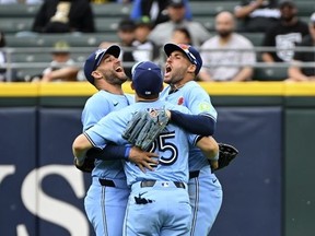 De gauche à droite, les voltigeurs des Blue Jays Kevin Kiermaier, Daulton Varsho et George Springer célèbrent la victoire de leur équipe contre les White Sox de Chicago au Garantie Rate Field le 27 mai 2024 à Chicago.