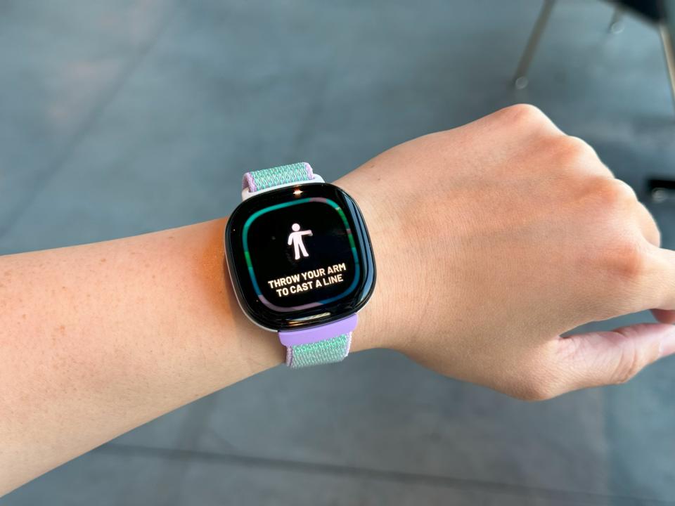 Le Fitbit Ace LTE sur un poignet tenu en l'air, avec les mots 