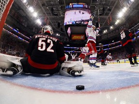 Artemi Panarin des Rangers de New York marque le but gagnant devant Pyotr Kochetkov des Hurricanes de la Caroline lors de la première prolongation du troisième match du deuxième tour des séries éliminatoires de la Coupe Stanley 2024 au PNC Arena le 9 mai 2024 à Raleigh, Caroline du Nord.