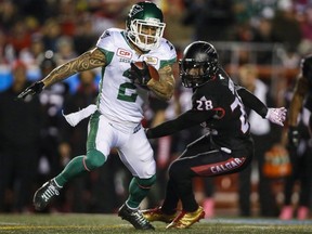 Une carrière qui a débuté sur la liste d'entraînement a valu à Chad Owens une place au Temple de la renommée du football canadien.  Owens, à gauche, passe le ballon devant Brandon Smith des Stampeders de Calgary lors de la première mi-temps d'un match de football de la LCF à Calgary, le vendredi 20 octobre 2017. LA PRESSE CANADIENNE/Jeff McIntosh