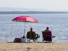 Les gens se rendent dans les eaux et les rives de la rivière des Outaouais, dans la banlieue d'Ottawa, Constance Bay, le mardi 6 juillet 2023.