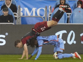 Le défenseur du Toronto FC Sigurd Rosted (17 ans) tombe sur l'attaquant de New York Malachi Jones (88 ans) lors de la première mi-temps de la MLS à Toronto, le samedi 11 mai 2024.