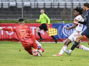 Le gardien de but du CS Saint-Laurent, Konstantinos Maniatis, arrête Deandre Kerr (29 ans) du Toronto FC lors de la première moitié du quart de finale du Championnat canadien de football à Montréal, le mercredi 8 mai 2024.