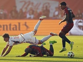 Bret Halsey (15) du FC Cincinnati tombe sur Deybi Flores (20) du FC Toronto, sous le regard de Jahkeele Marshall-Rutty (7) lors de l'action de football MLS à Toronto, le samedi 25 mai 2024. Le FC Toronto cherche à resserrer sa défense alors qu'il se dirige vers le sud pour les matchs de mercredi contre l'Union de Philadelphie et samedi contre DC United.