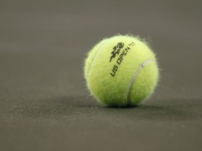 DOSSIER - Une balle de tennis sur le terrain lors du premier tour du tournoi de tennis de l'US Open à New York, le mardi 30 août 2011. Un joueur de tennis s'est vu accorder 9 millions de dollars de dommages et intérêts par un jury d'un tribunal fédéral de Floride après l'avoir accusé l'Association américaine de tennis de ne pas l'avoir protégée contre un entraîneur qui, selon elle, l'avait agressée sexuellement dans l'un de ses centres de formation alors qu'elle avait 19 ans.