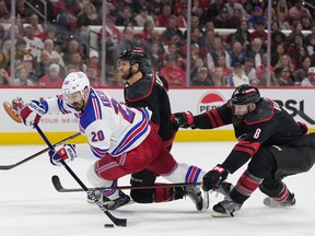 Chris Kreider des Rangers de New York tire la rondelle pendant que Jaccob Slavin et Brent Burns des Hurricanes de la Caroline défendent lors du sixième match au PNC Arena le 16 mai 2024 à Raleigh, en Caroline du Nord.