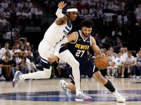 Jamal Murray, à droite, des Denver Nuggets, est victime d'une faute de Jaden McDaniels des Minnesota Timberwolves lors du troisième quart du match 4 des éliminatoires du deuxième tour de la Conférence Ouest au Target Center, le dimanche 12 mai 2024, à Minneapolis, Minnesota.