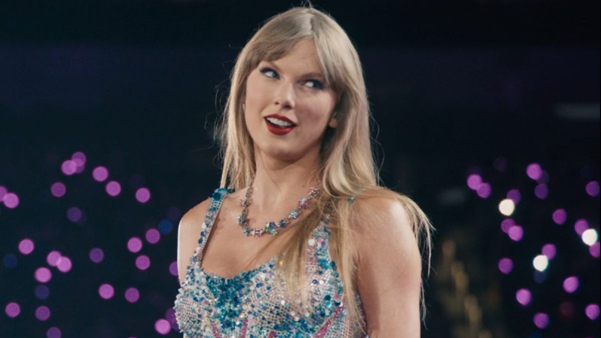 Taylor Swift looking over her shoulder and smiling during the Lover set of The Eras Tour.