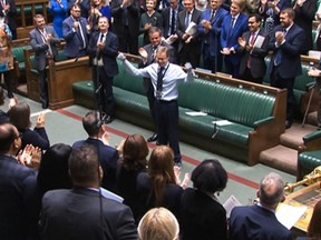 Une capture vidéo d'images diffusées par l'Unité d'enregistrement parlementaire (PRU) du Parlement britannique montre le député conservateur britannique Craig Mackinlay reconnaissant les applaudissements et les acclamations, à la Chambre des communes, à Londres, le 22 mai 2024, le jour de son retour après ses mains et ses pieds ont été amputés après avoir contracté une septicémie.