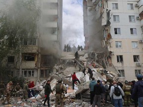 Des pompiers et des volontaires opèrent pour sécuriser la zone sur le site d'un immeuble partiellement effondré qui a été endommagé par une frappe ukrainienne à Belgorod le 12 mai 2024.