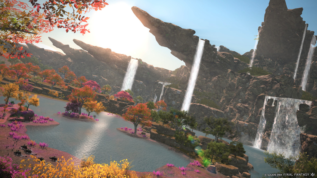 Une image de Final Fantasy 14 représentant des cascades tombant en cascade sur de grands affleurements rocheux jusqu'à un grand lac entouré de fleurs jaunes et roses éclatantes.