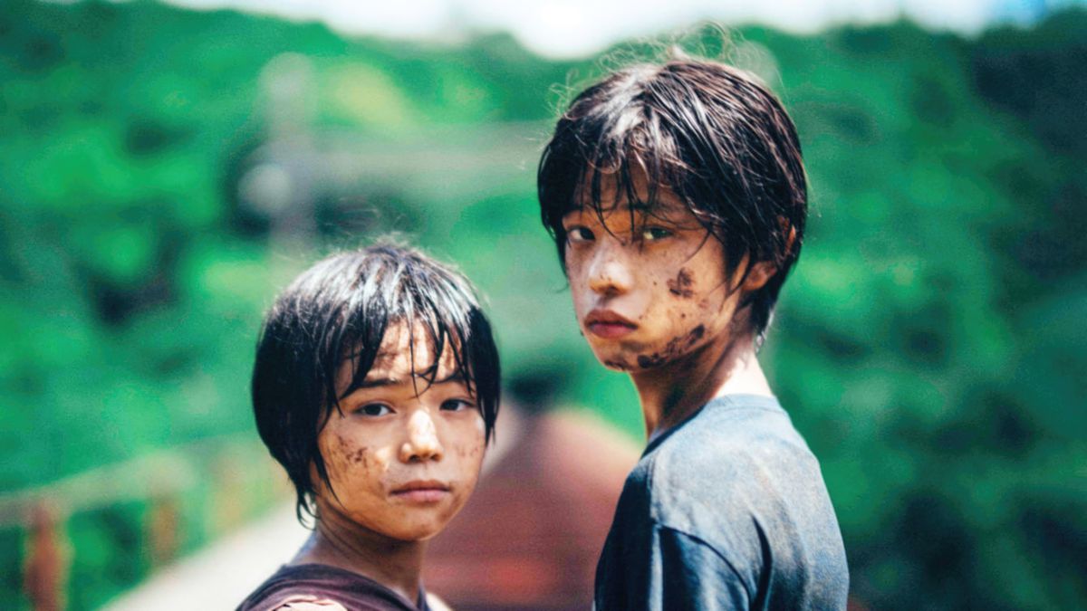 Deux jeunes enfants japonais couverts de terre, regardant la caméra