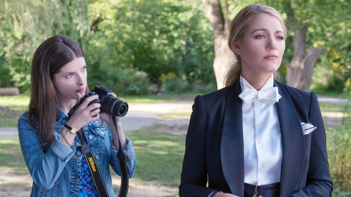 Anna Kendrick prend une photo de Blake Lively, vêtue d'un costume avec un nœud papillon blanc, dans A Simple Favor