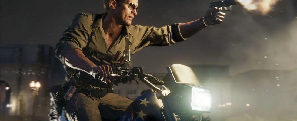 A man wearing sunglasses sitting an a motorbike, aiming a pistol in his left hand.