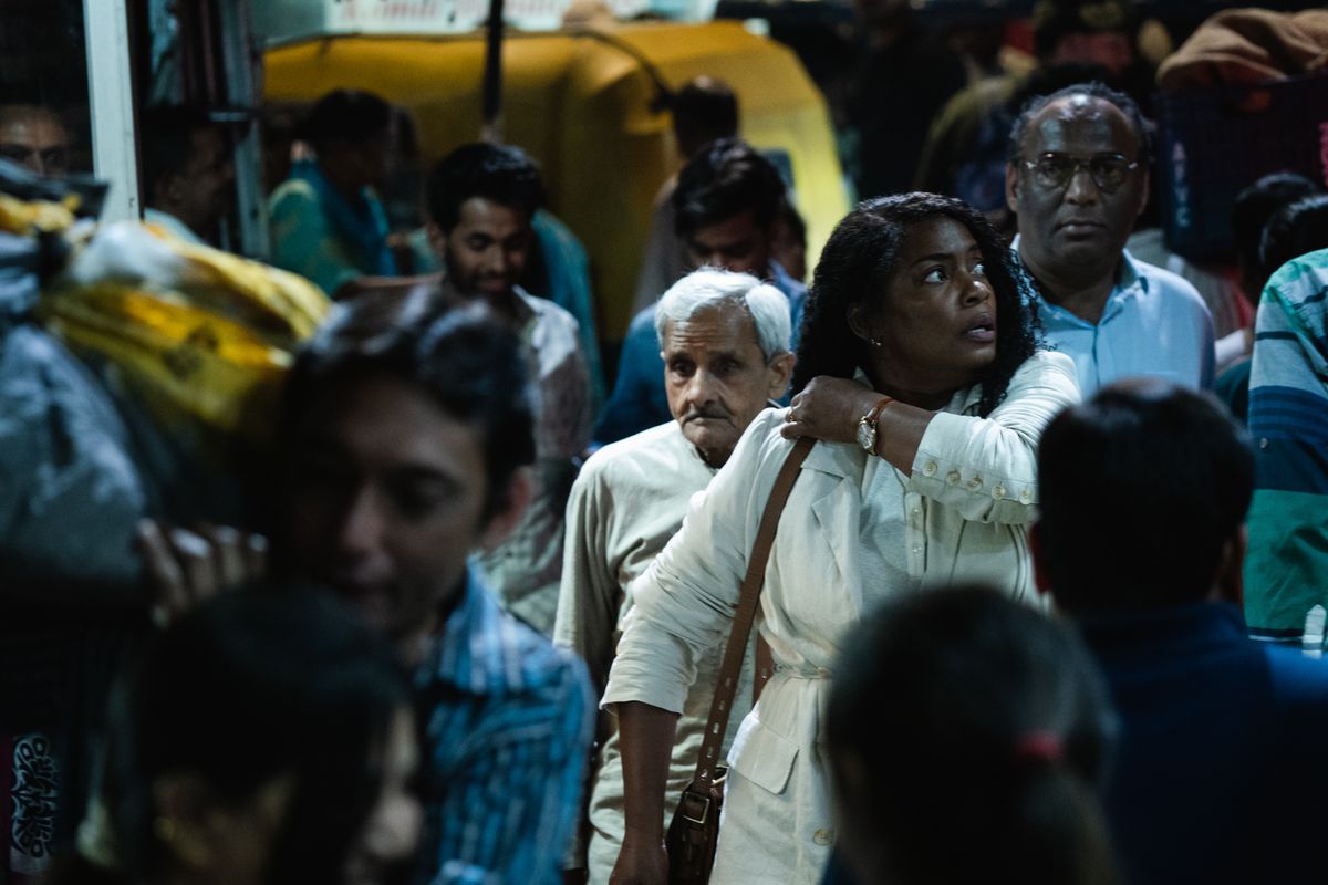 Aunjanue Ellis-Taylor traverse une foule d'Indiens, l'air désorienté et sexy, dans Origin