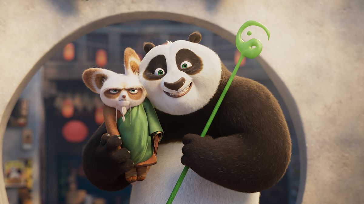 Un panda anthropomorphe tenant dans ses bras un sceptre vert et un panda roux tout en souriant.