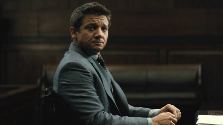 Jeremy Renner sits in a hearing room with a rather upset look in Mission Impossible: Rogue Nation.