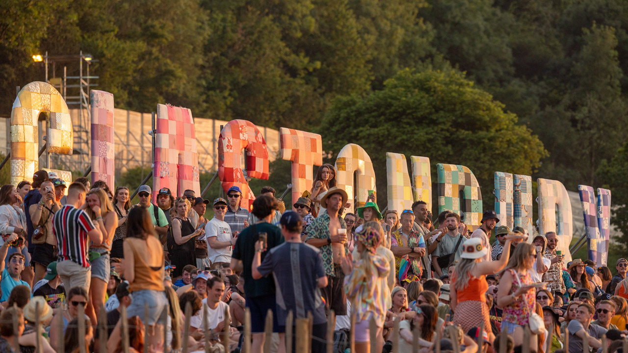 Les foules se rassemblent sous le panneau Glastonbury pour admirer le coucher du soleil pendant la première journée du festival de Glastonbury à Worthy Farm, Pilton