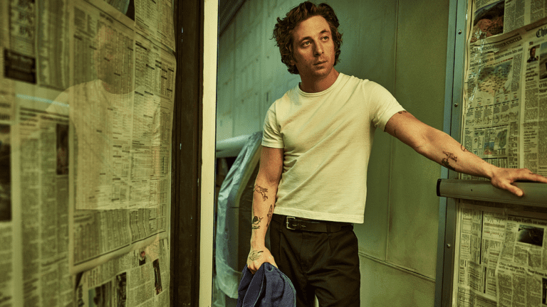 Carmy (Jeremy Allen White) leans on the open door of a newspaper-lined room in The Bear