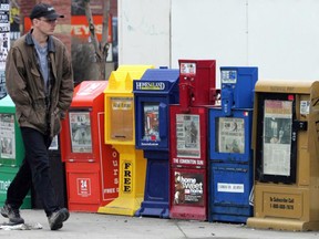 Des boîtes à journaux sur un trottoir.