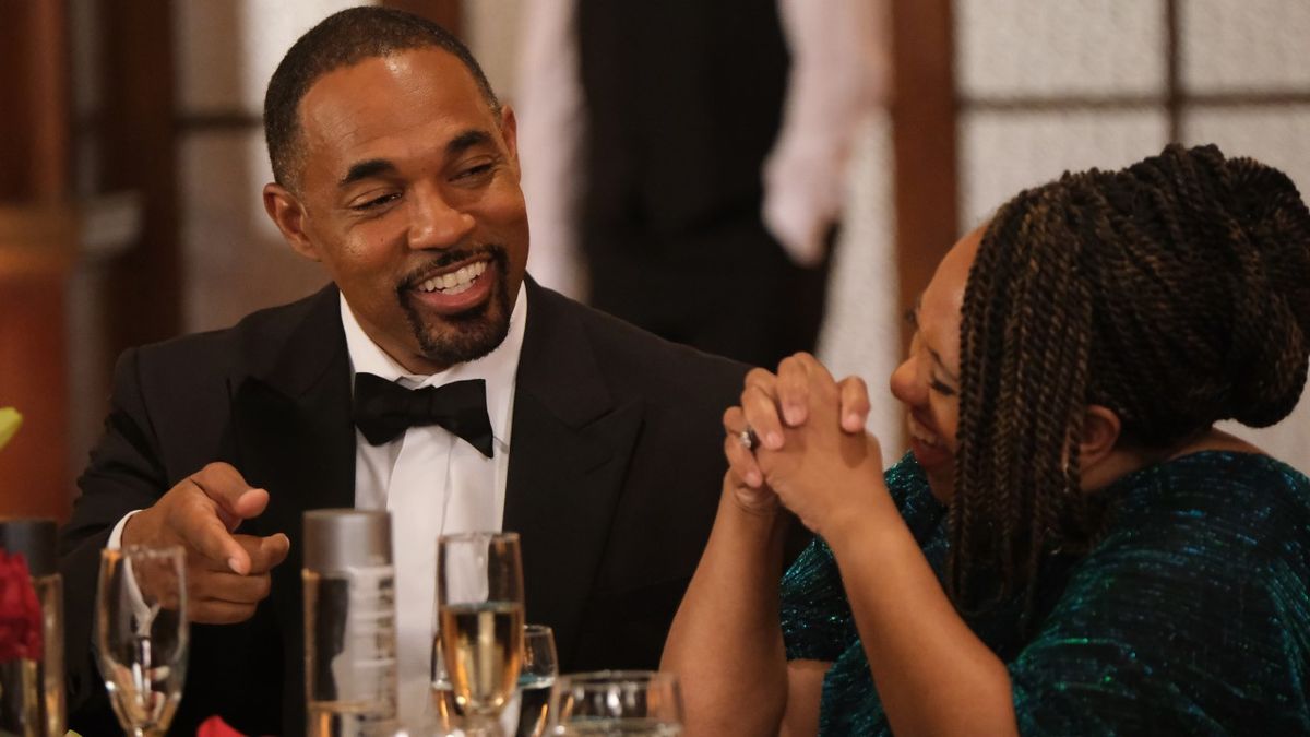 Jason George as Ben Warren laughs with Chandra Wilson as Miranda Bailey as they sit at a table during a firefighters banquet on the May 18, 2024, episode of Station 19, 