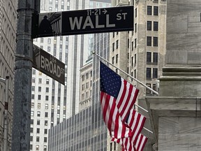 Des drapeaux américains sont suspendus devant la Bourse de New York, à droite, le jeudi 11 avril 2024 à New York.