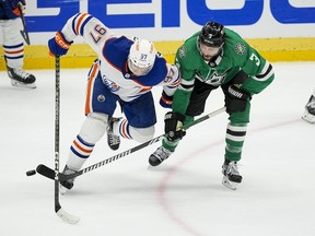 Le centre des Oilers d'Edmonton Connor McDavid est en compétition pour la rondelle contre le défenseur des Stars de Dallas Chris Tanev (3) lors des séries éliminatoires de la LNH, le jeudi 23 mai 2024, à Dallas.  L'entraîneur-chef des Stars, Pete DeBoer, est "optimiste" Tanev participera ce soir au cinquième match de la finale de la Conférence Ouest de la LNH contre les Oilers d'Edmonton.