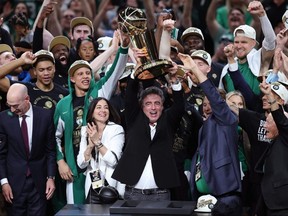 Le propriétaire majoritaire Wyc Grousbeck des Boston Celtics brandit le trophée du championnat Larry O'Brien après la victoire 106-88 de Boston contre les Dallas Mavericks lors du cinquième match de la finale NBA 2024 au TD Garden le 17 juin 2024 à Boston.