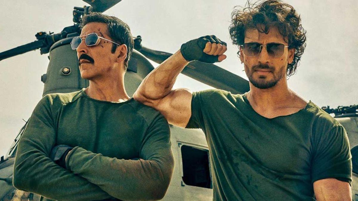 Tiger Shroff fléchit son biceps, appuyé sur l'épaule d'Akshay Kumar, devant un hélicoptère à Bade Miyan Chote Miyan.  Kumar croise les bras.