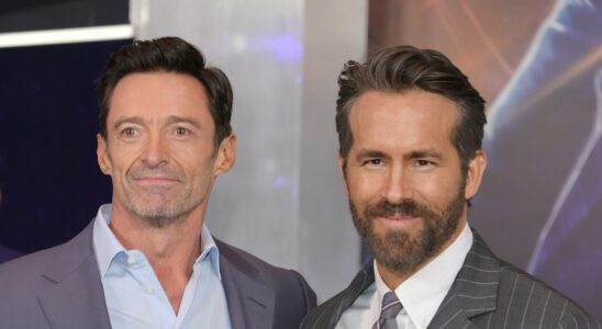 Ryan Reynolds and Hugh Jackman smiling on the red carpet of The Adam Project