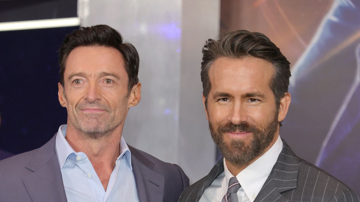 Ryan Reynolds and Hugh Jackman smiling on the red carpet of The Adam Project