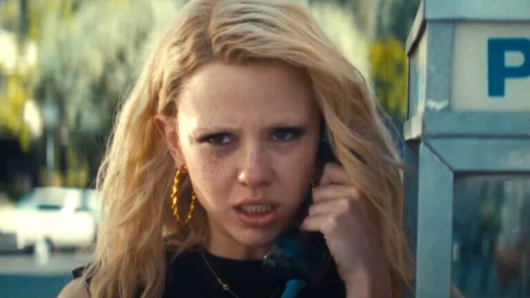 Mia Goth as Maxine Minx talks on a pay phone in the trailer for MaXXXine.