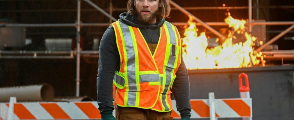 Max Thieriot as Bode standing in front of a fire wearing a construction vest in the Season 2 finale of Fire Country.