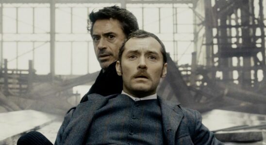 Jude Law and Robert Downey Jr sitting in shock in Sherlock Holmes.