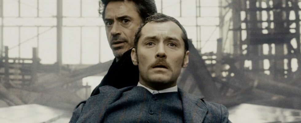 Jude Law and Robert Downey Jr sitting in shock in Sherlock Holmes.