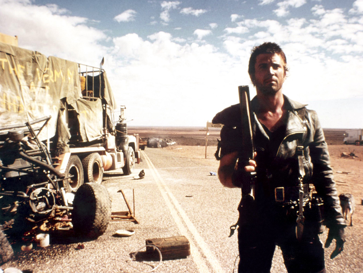 Max brandissant un fusil de chasse sur la route dans Mad Max 2 The Road Warrior