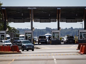 Un agent de l'Agence des services frontaliers du Canada se profile alors que des automobilistes entrent au Canada au poste frontalier de Douglas-Peace Arch, à Surrey, en Colombie-Britannique, le lundi 9 août 2021. Alors que la saison estivale des voyages démarre, les Canadiens et les visiteurs pourraient se retrouver de longues files d'attente à la frontière, des retards qui pourraient également porter un coup dur à l'économie.