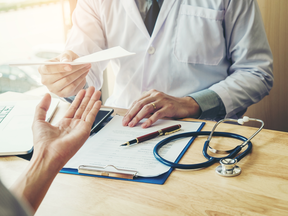 Le médecin rédige une note pour le patient