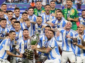 L'attaquant argentin #10 Lionel Messi soulève le trophée alors qu'il célèbre sa victoire lors de la finale du tournoi de football de la Copa America 2024 de la Conmebol entre l'Argentine et la Colombie au Hard Rock Stadium, à Miami, en Floride, le 14 juillet 2024. (Photo de CHARLY TRIBALLEAU / AFP)