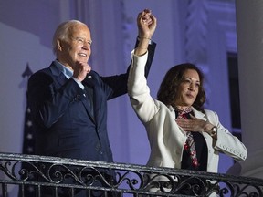 Le président Joe Biden lève la main de la vice-présidente Kamala Harris après avoir regardé le feu d'artifice du jour de l'indépendance au-dessus du National Mall depuis le balcon de la Maison Blanche, le jeudi 4 juillet 2024, à Washington.